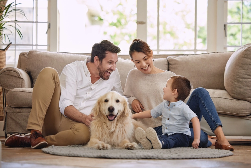 Happy family with dog on living room floor